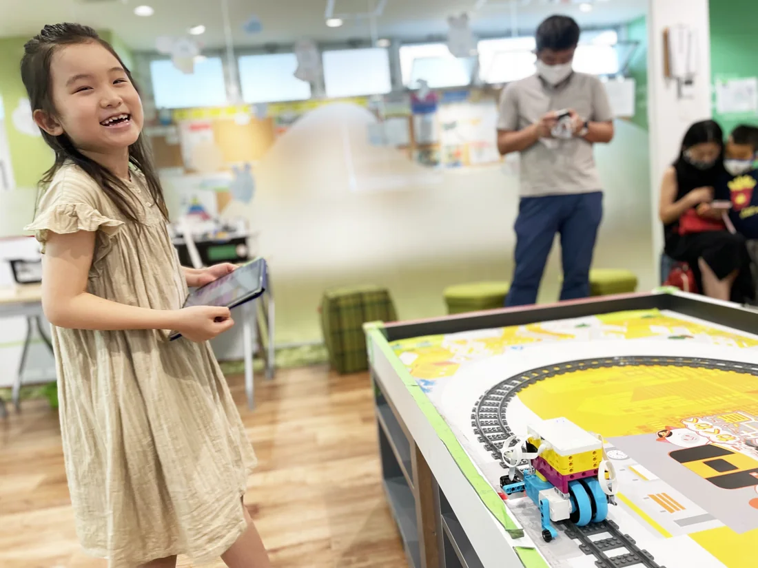 電車ロボットのそばで笑顔を見せる子ども